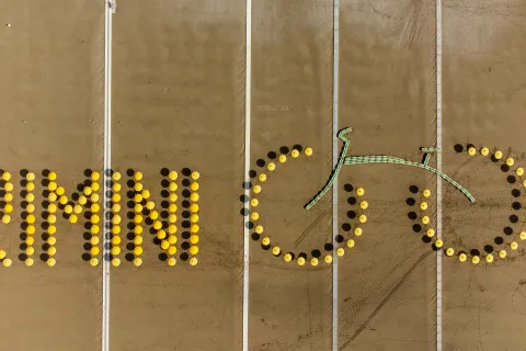 scritta rimini in giallo sulla spiaggia con gli ombrelloni